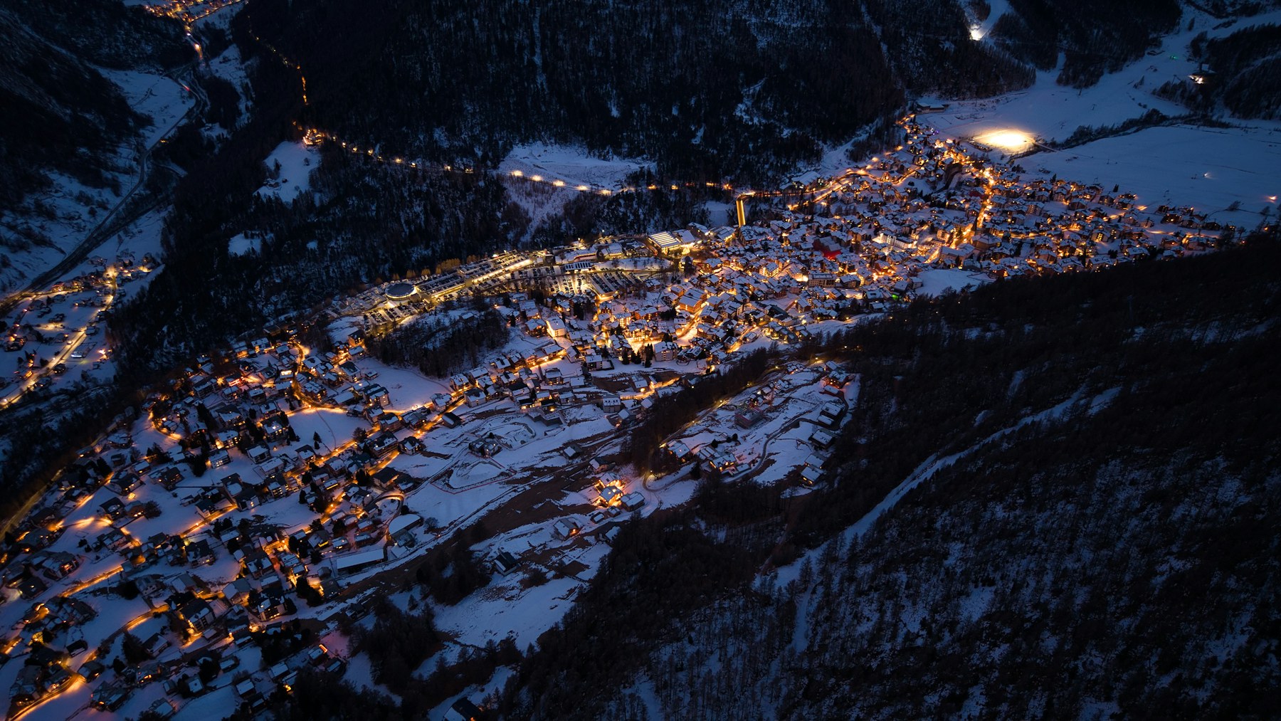 Zermatt lit up at night below the mountains