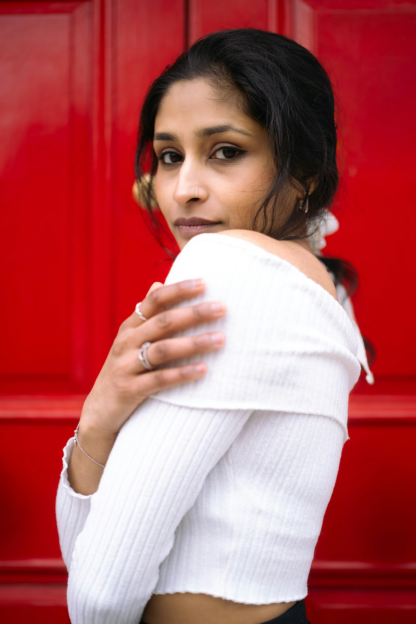 A woman in white against a red door