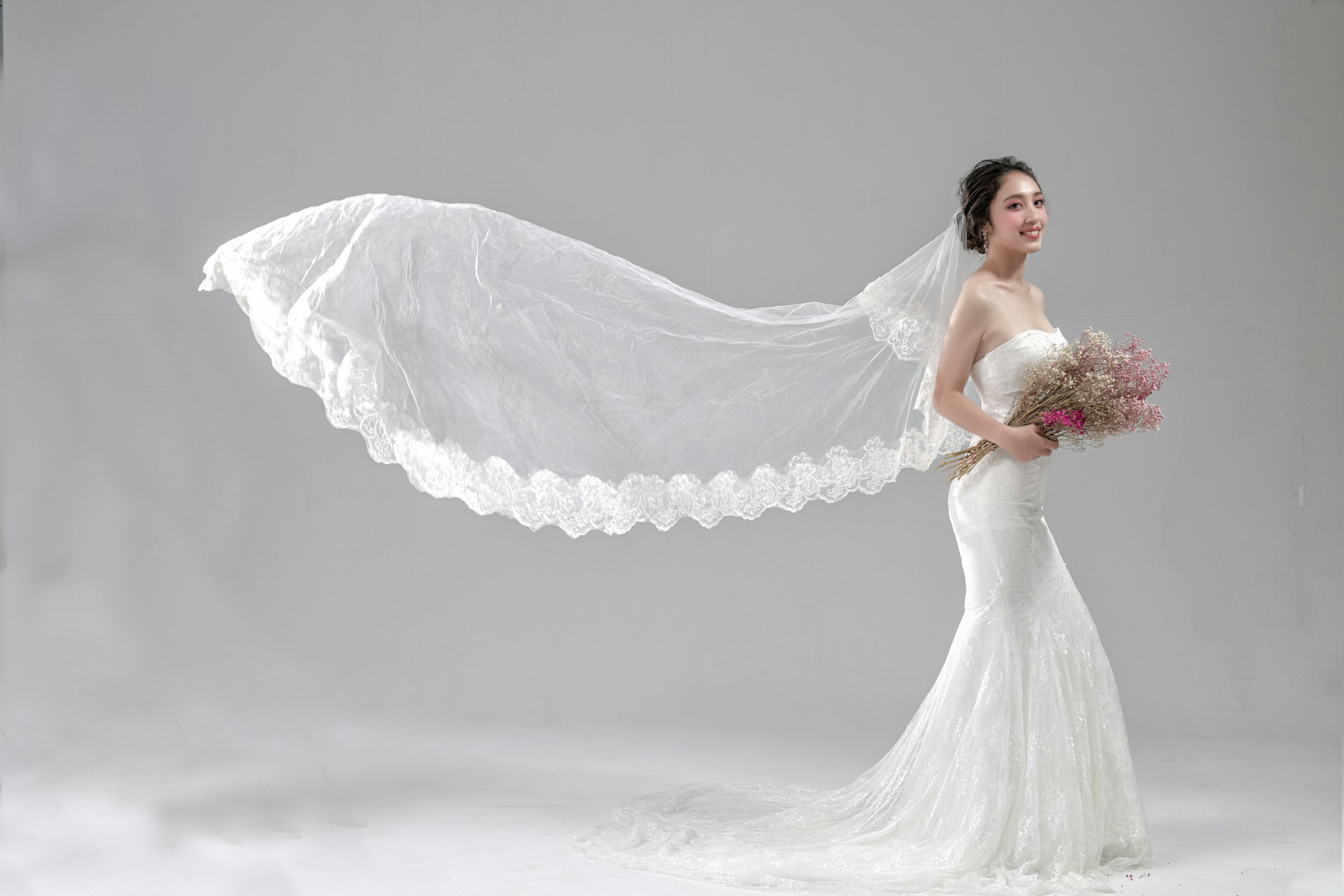 A bride with her veil flying in the wind
