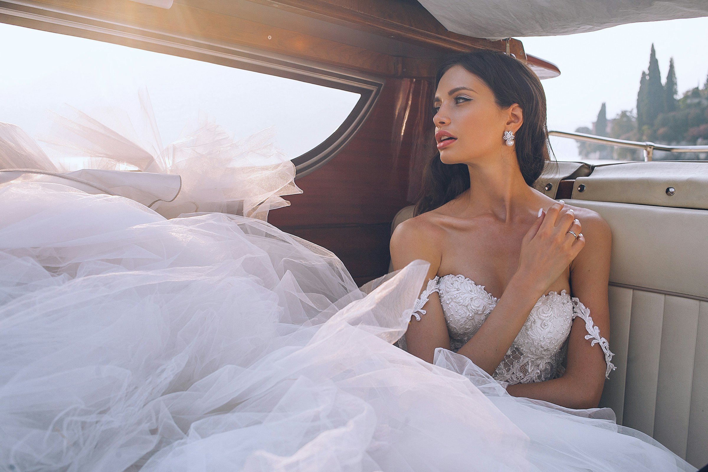 A bride in a cloud of tulle in a vintage car