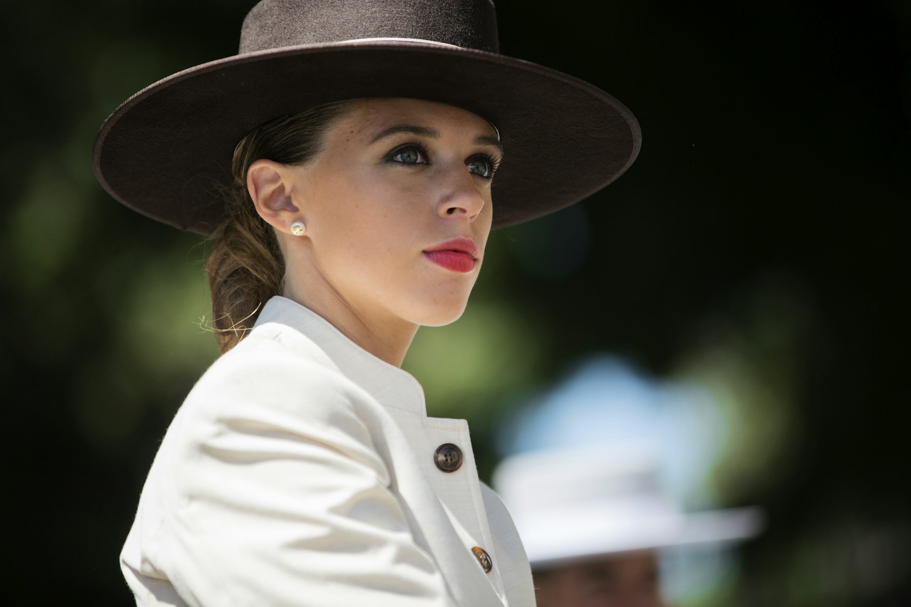 Woman in a white jacket and wide hat