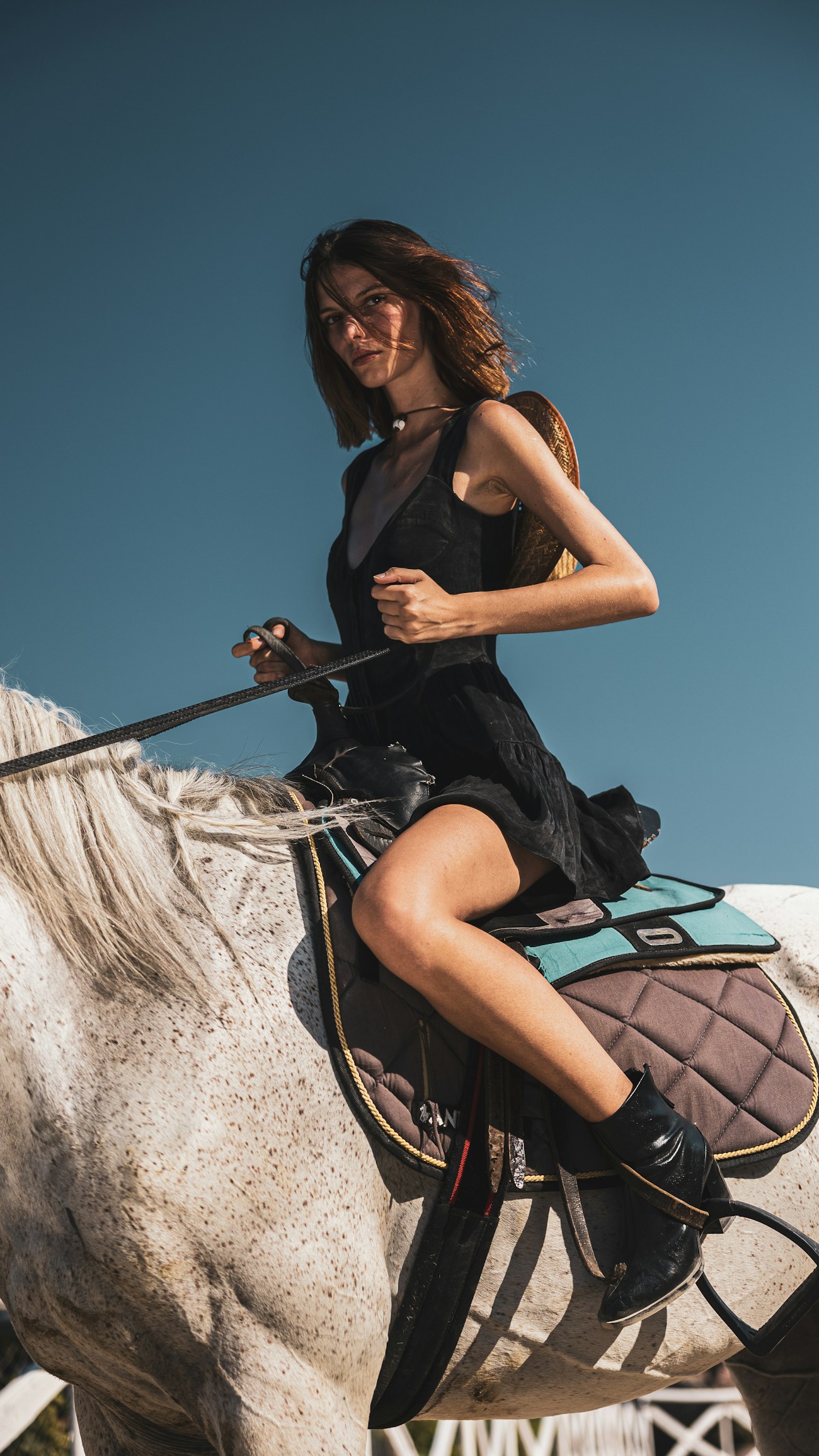 Rider in a black dress on a grey horse