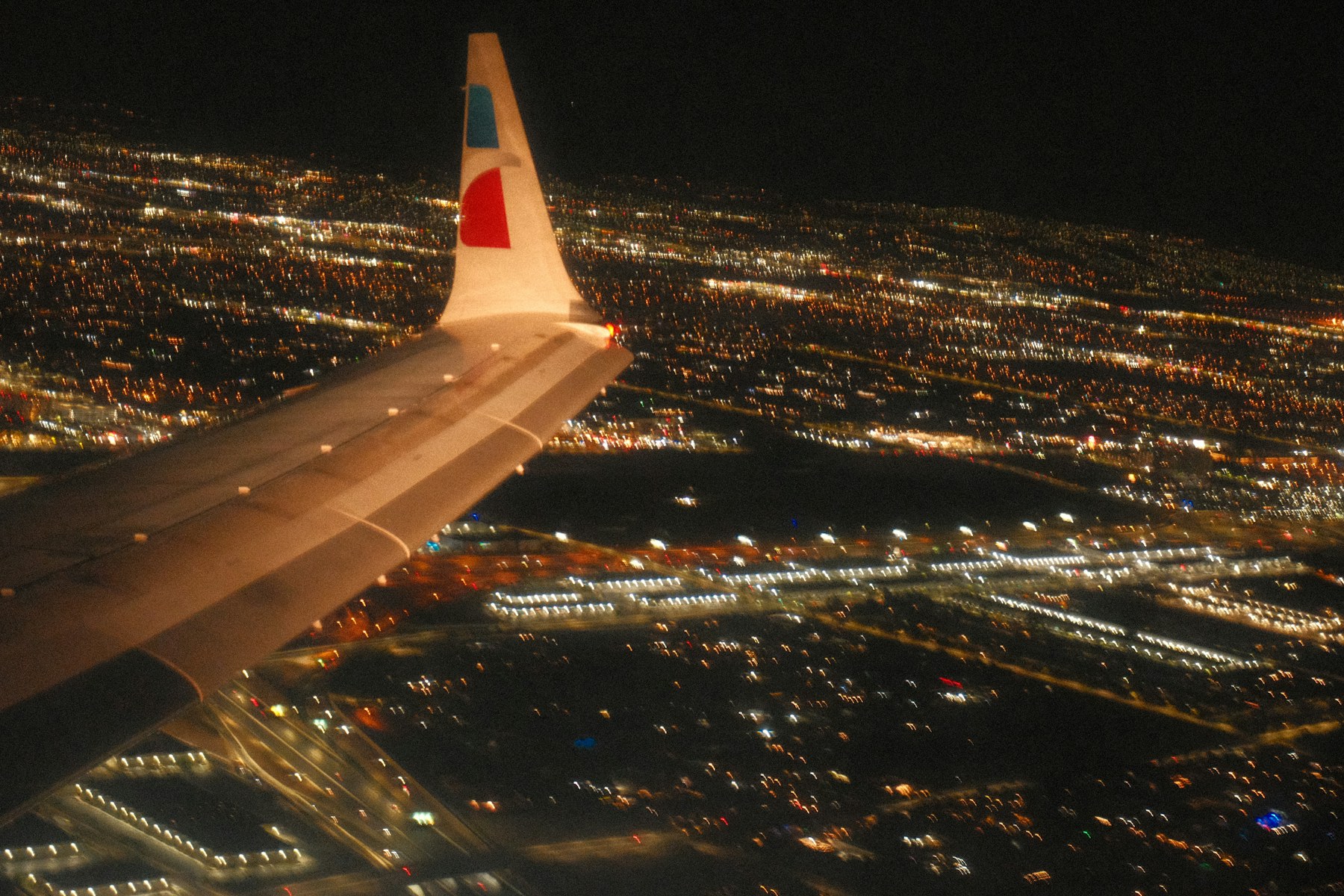 City lights under the wing at night