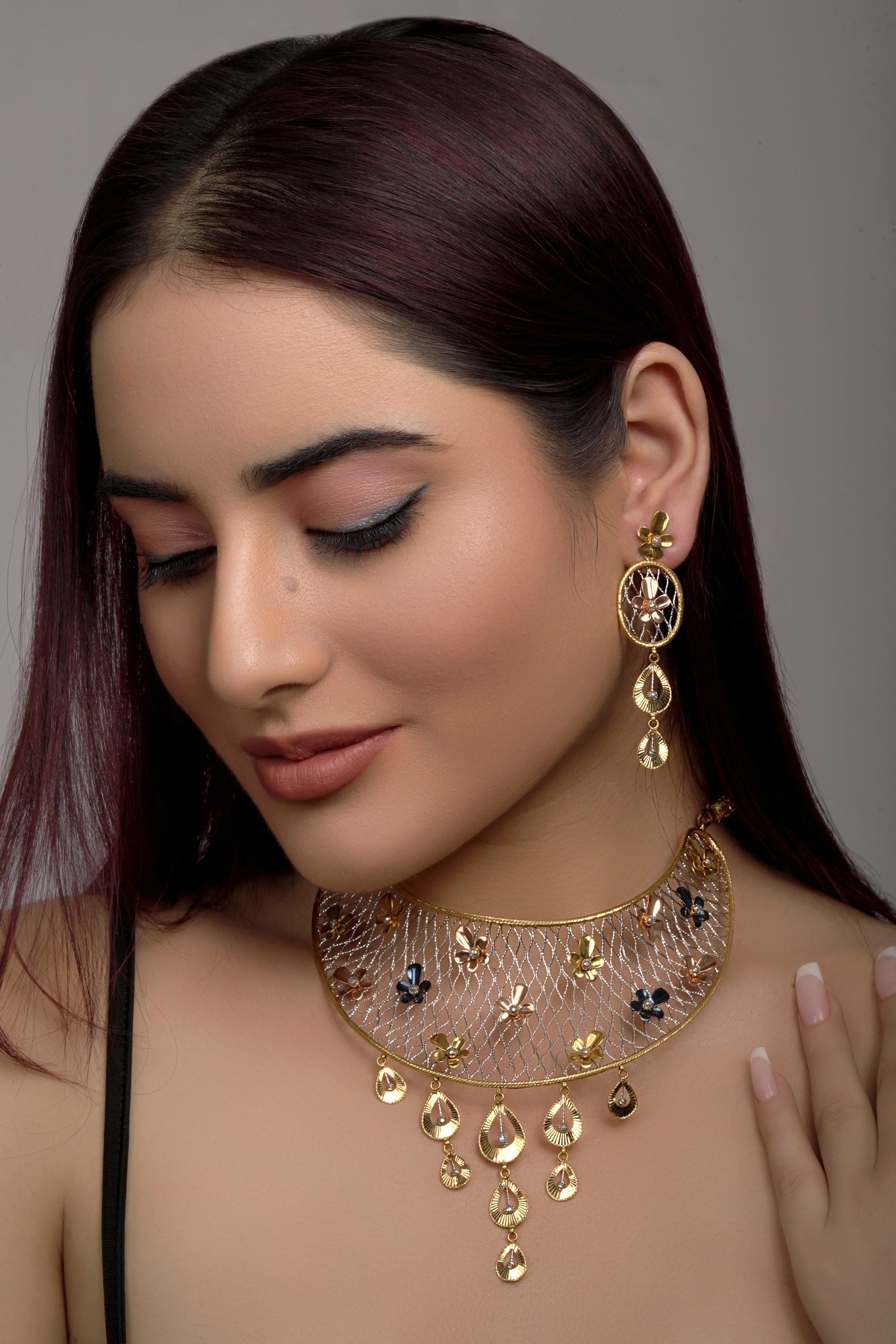 Model wearing a gold filigree collar and chandelier earrings