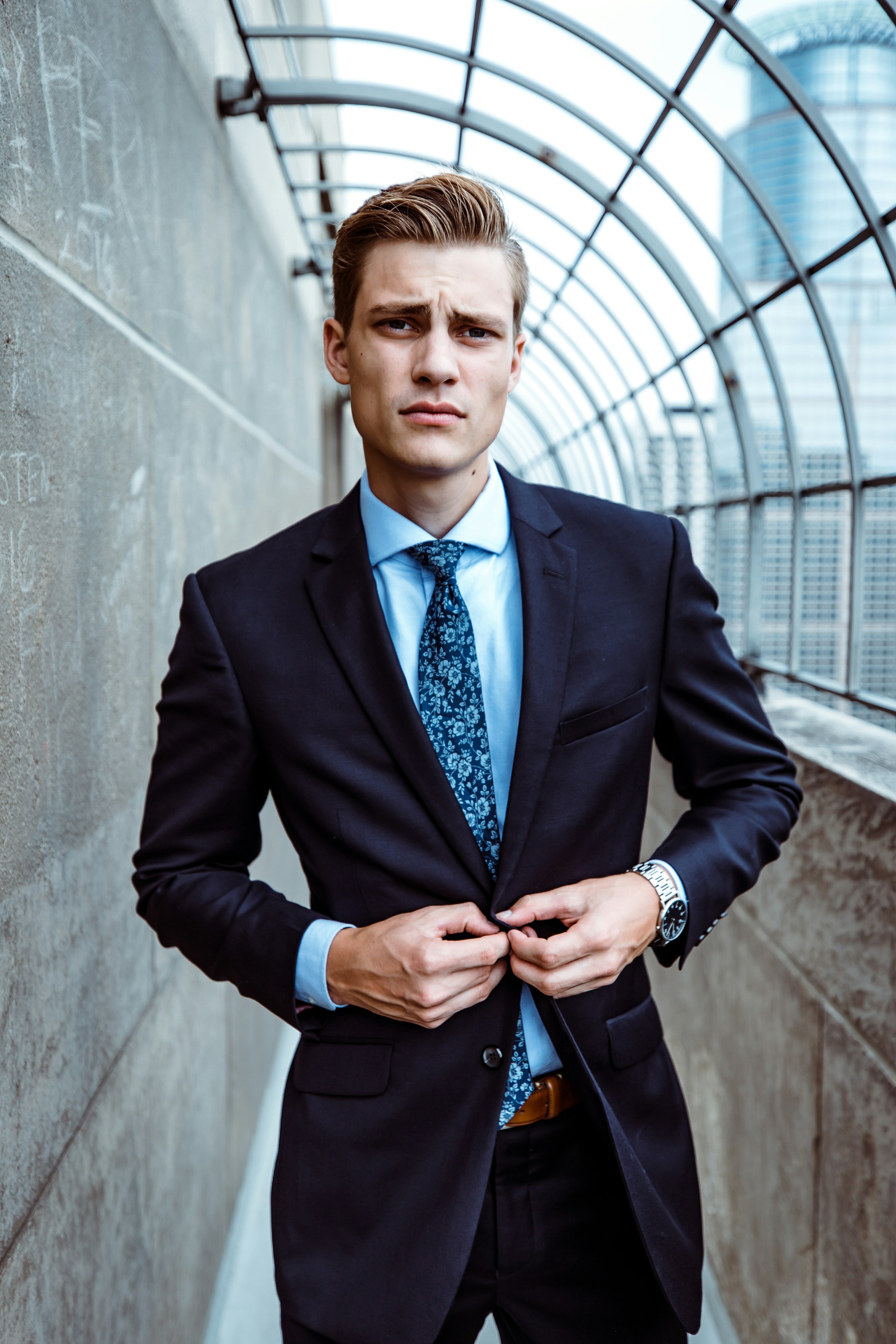 Client in a navy suit fastening his jacket