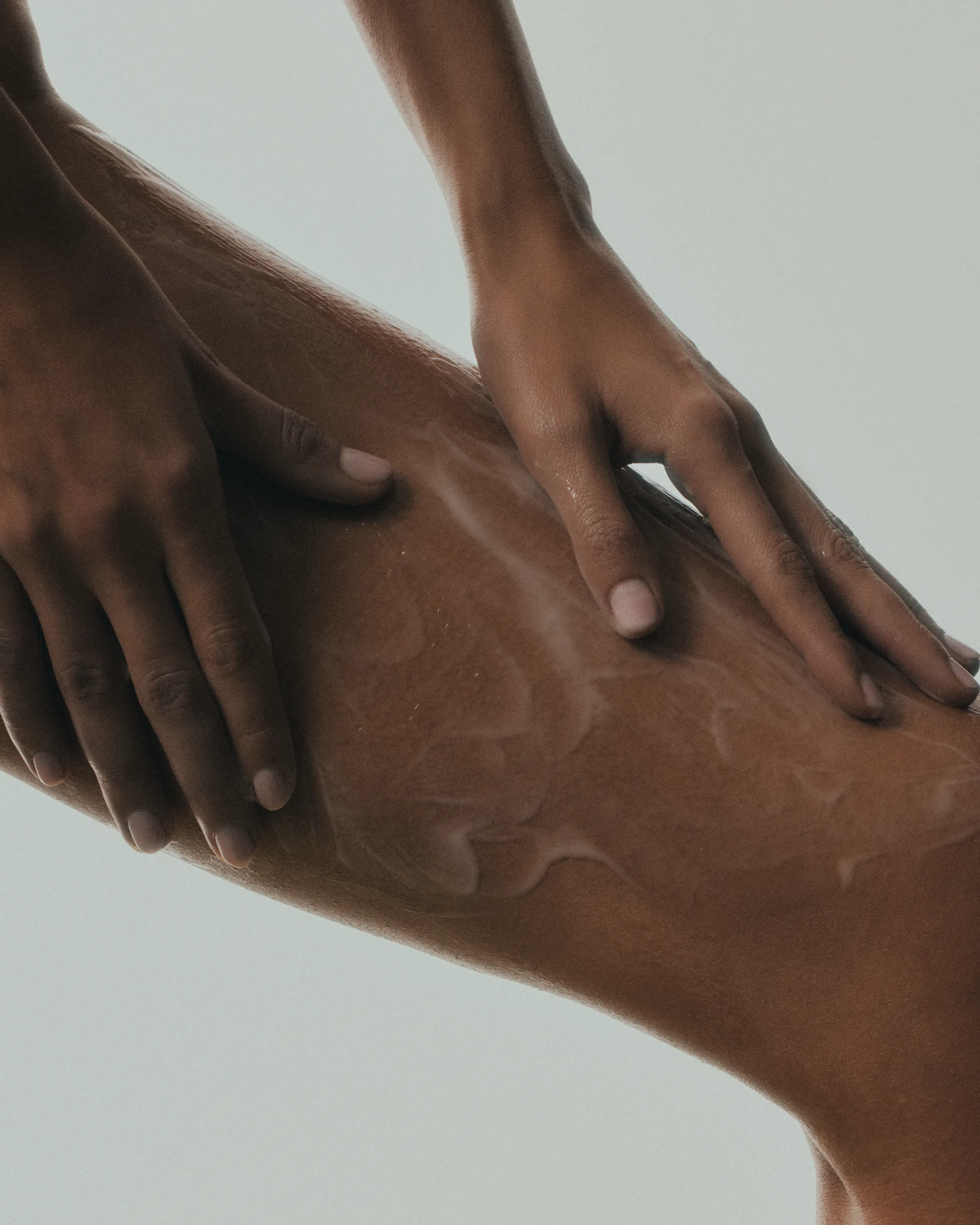 Hands smoothing serum across the skin