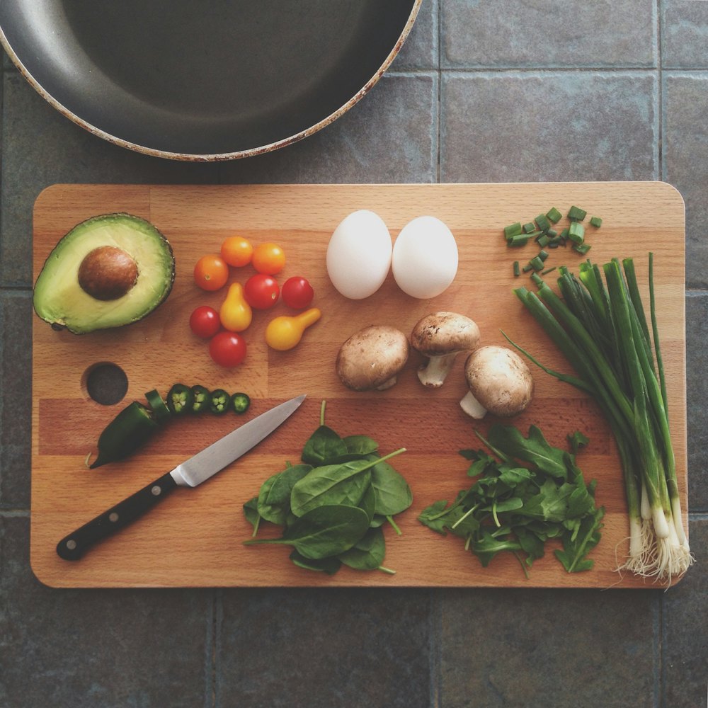 Chopping board with vegetables, eggs and a chef's knife