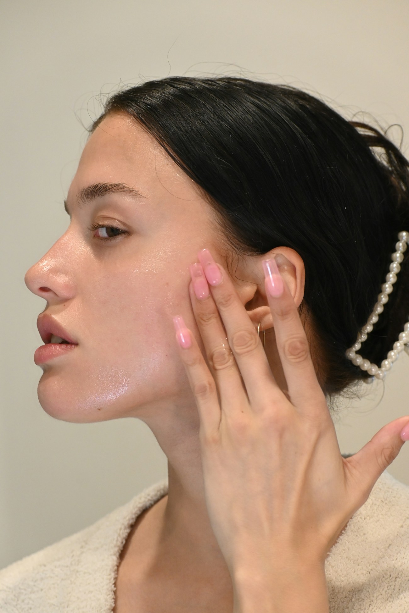 A woman with closed eyes touching her face