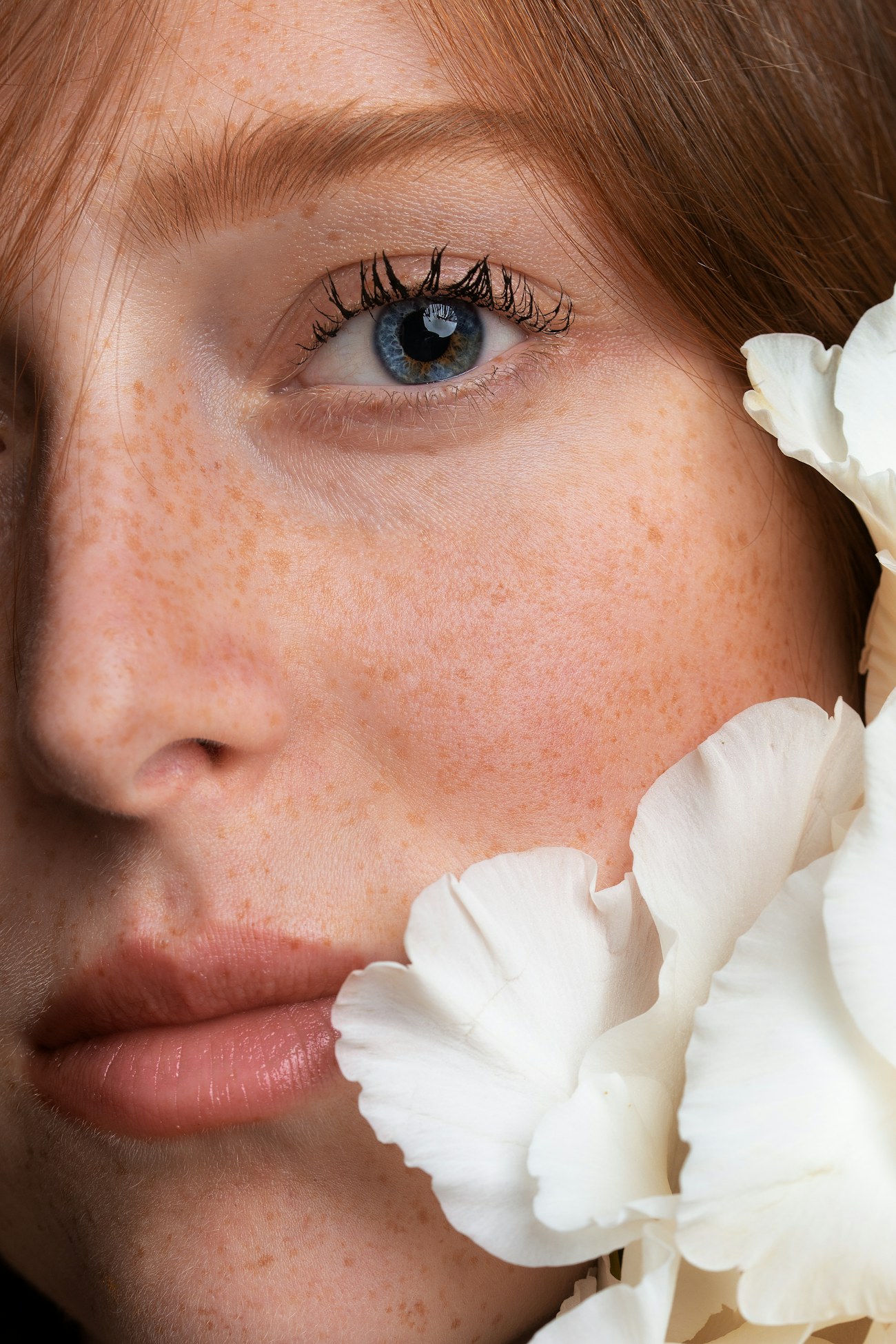 A woman with freckles and white flowers