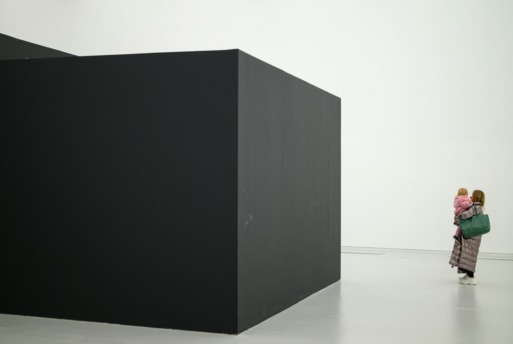 A black cube installation in a white gallery