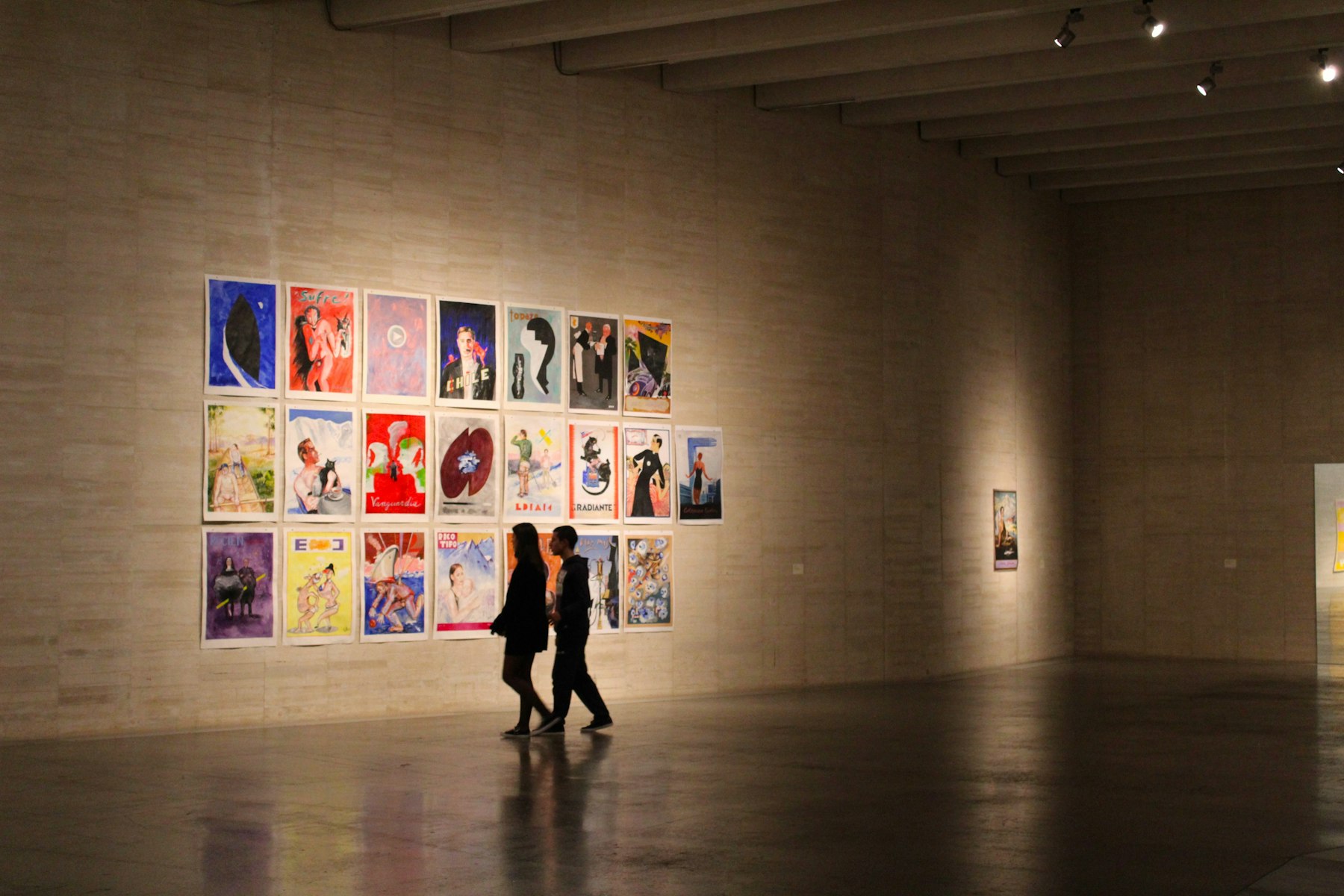 Visitors in a gallery hung salon-style