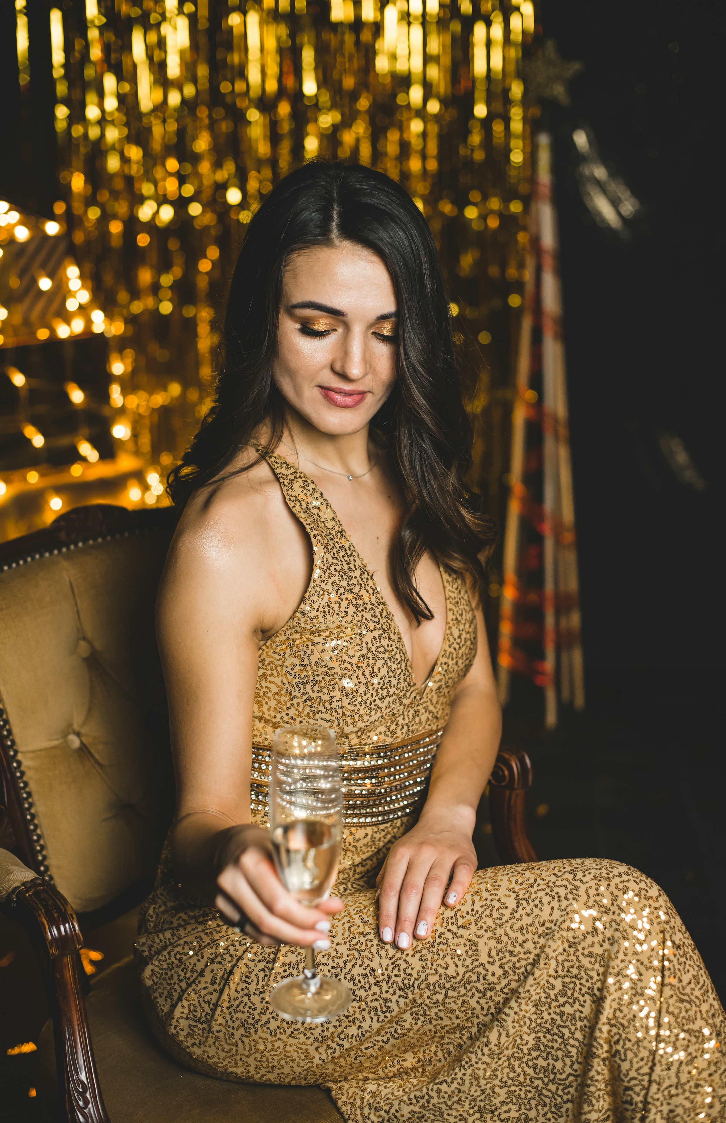 Woman in a gold sequin gown with champagne