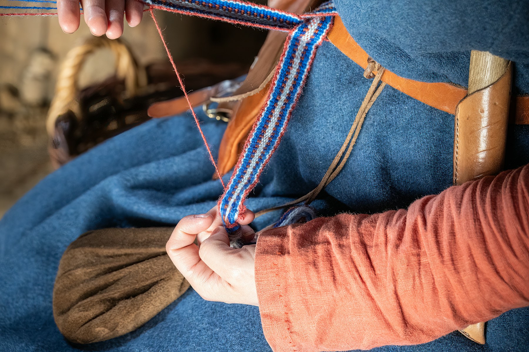 An artisan stitching leather by hand