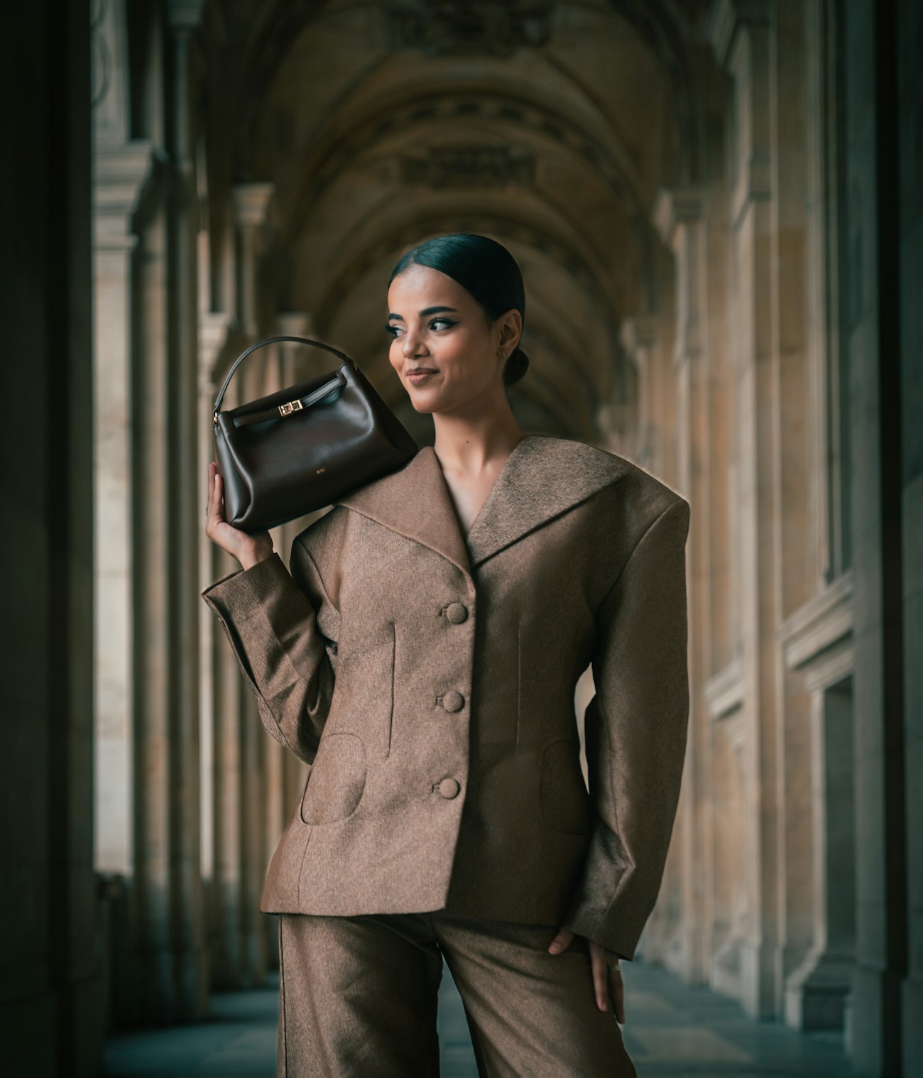 A woman carrying a VELLUM bag