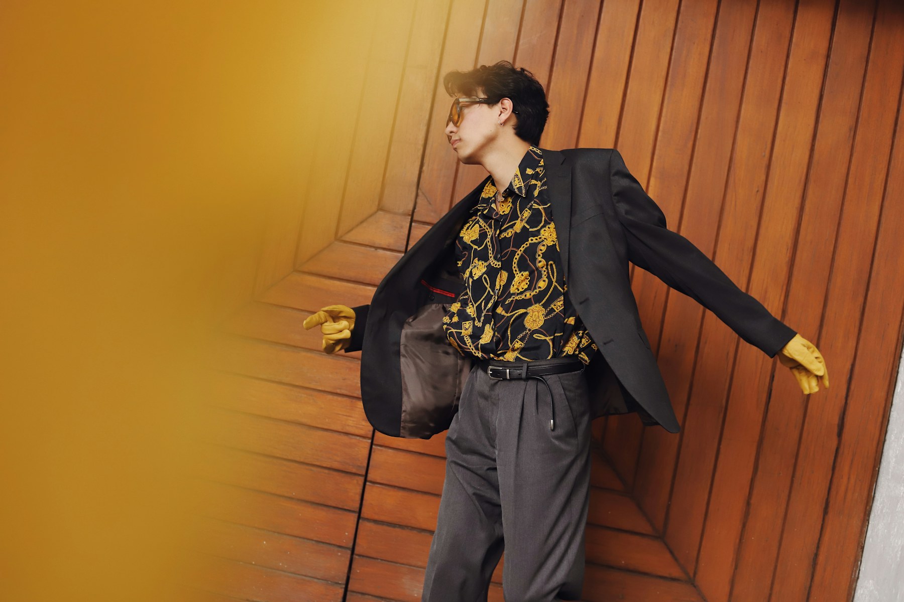 A man in a jacket against an orange wall