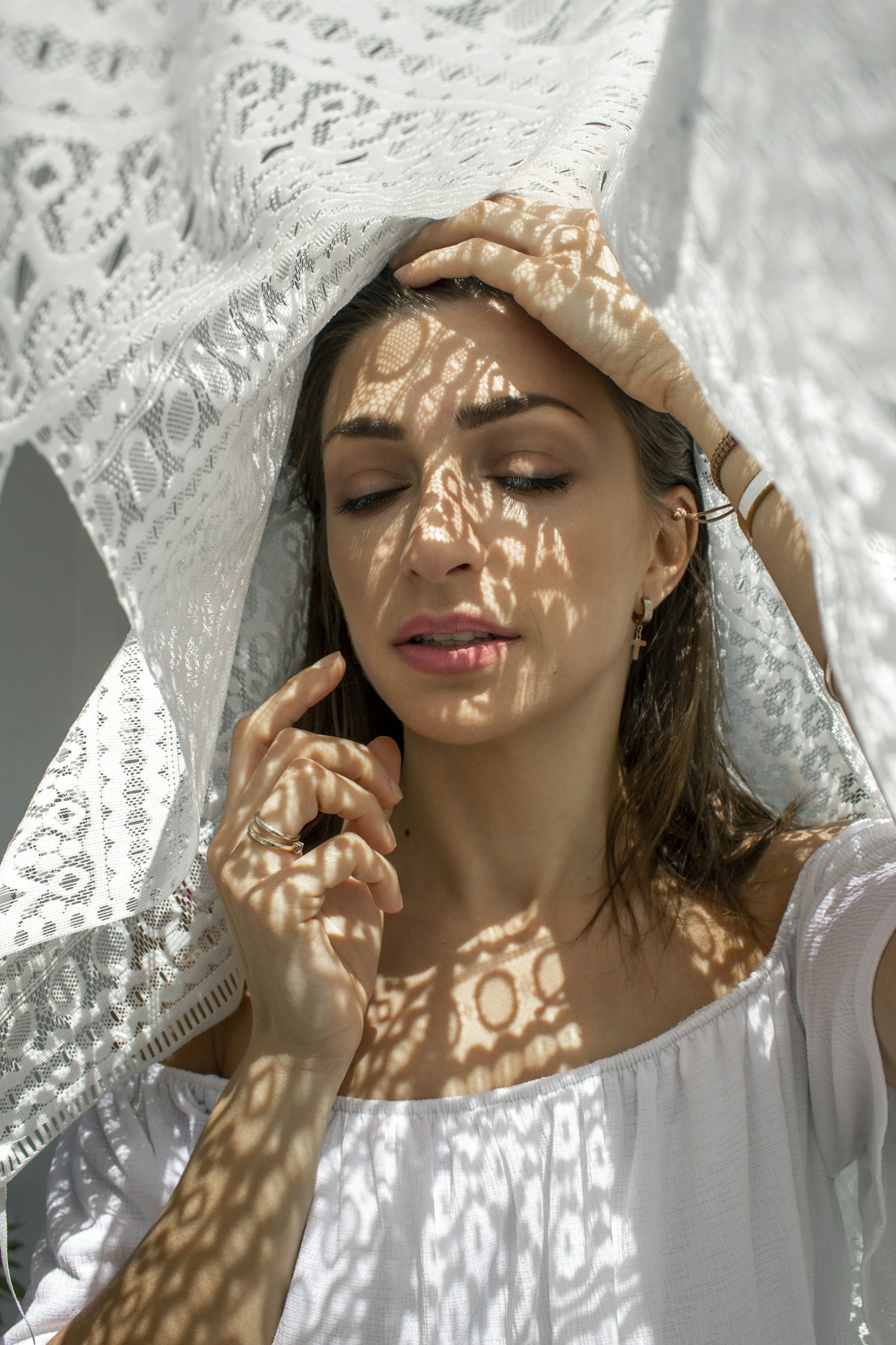 Sunlight through lace on a woman’s face